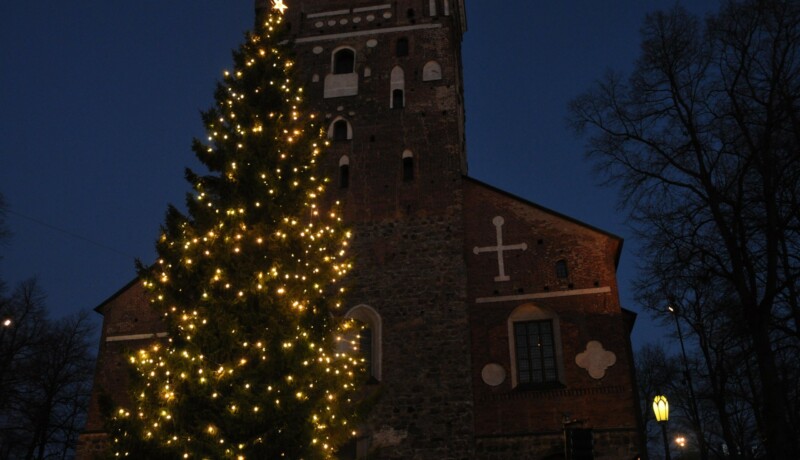 En stor julgran utanför en kyrka.