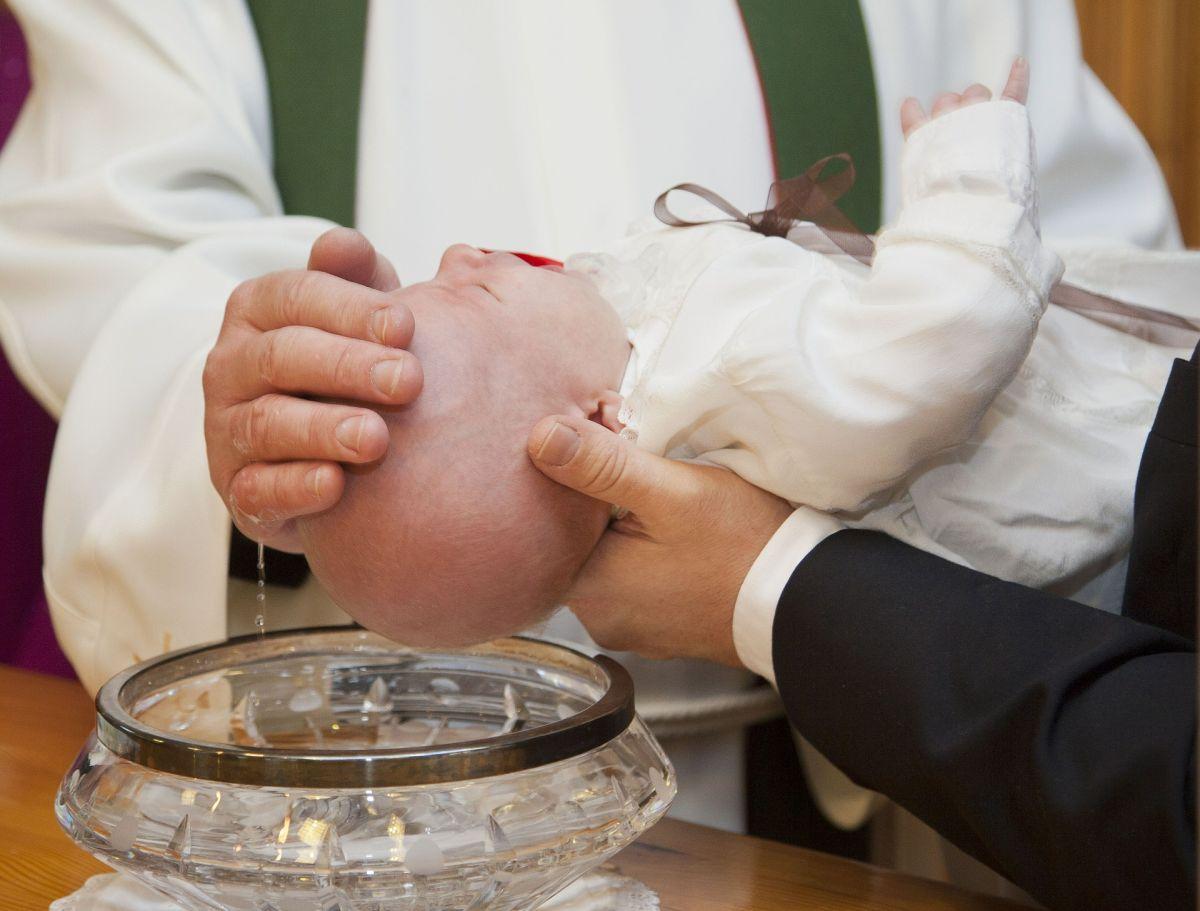 Ett barn döps i en kyrka.