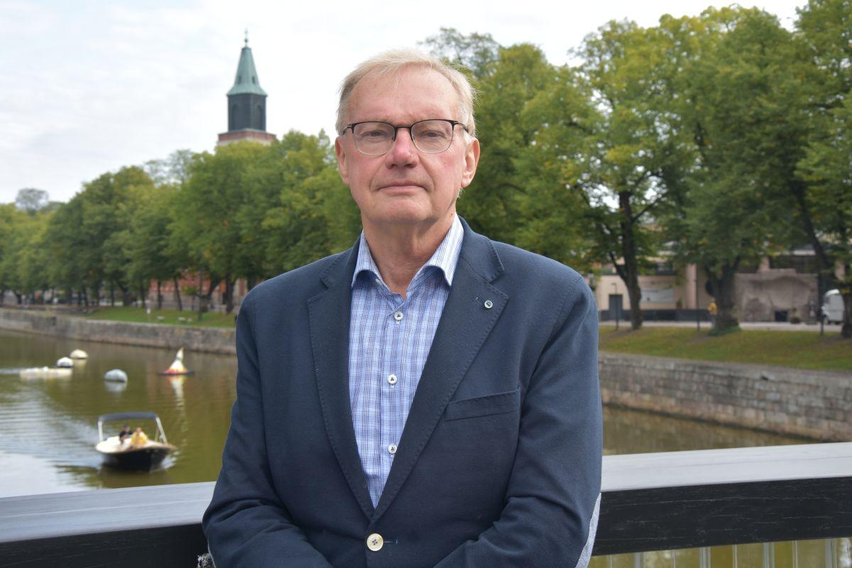 En man står på en bro över Aura å