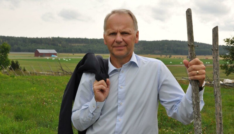 Man med kavaj på axeln.