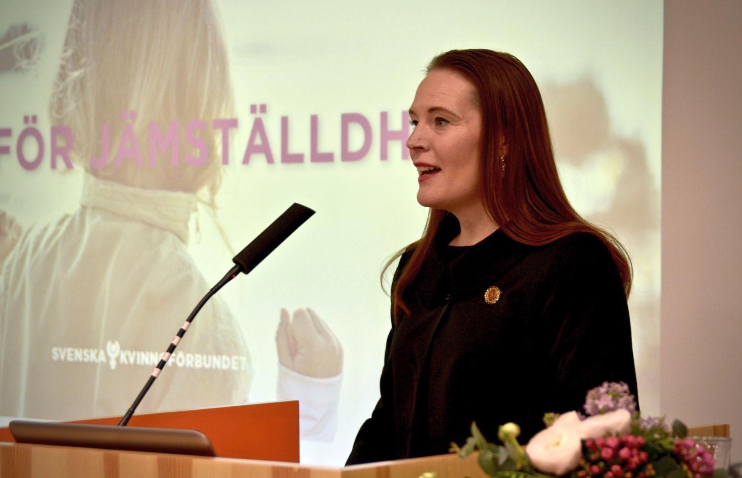 Kvinna talar i mikrofron