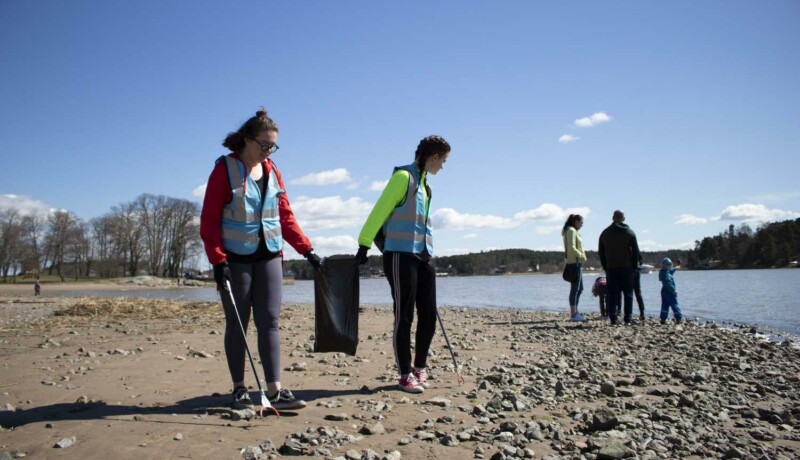 N¨gra människor städar på en strand.