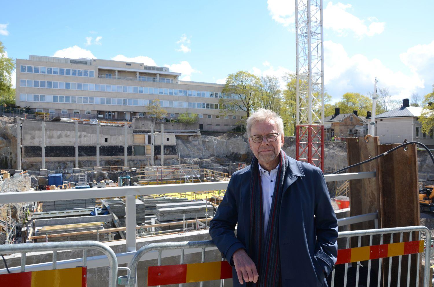 Mikko Hupa på bild framför byggplatsen.