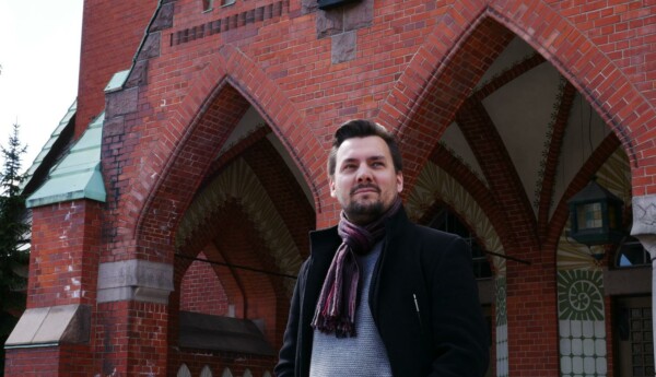En man står framför en kyrka