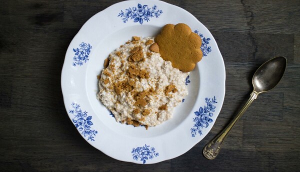 En tallrik gröt prydd med en pepparkaka står på ett bord.
