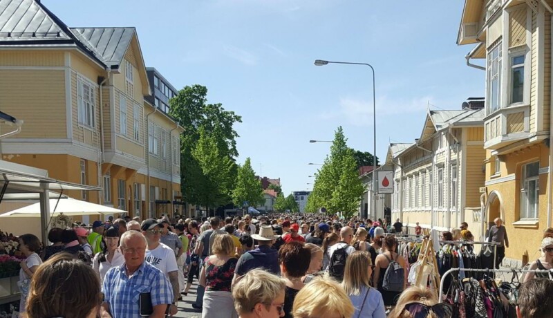 Mycket människor på en gata med trähus.
