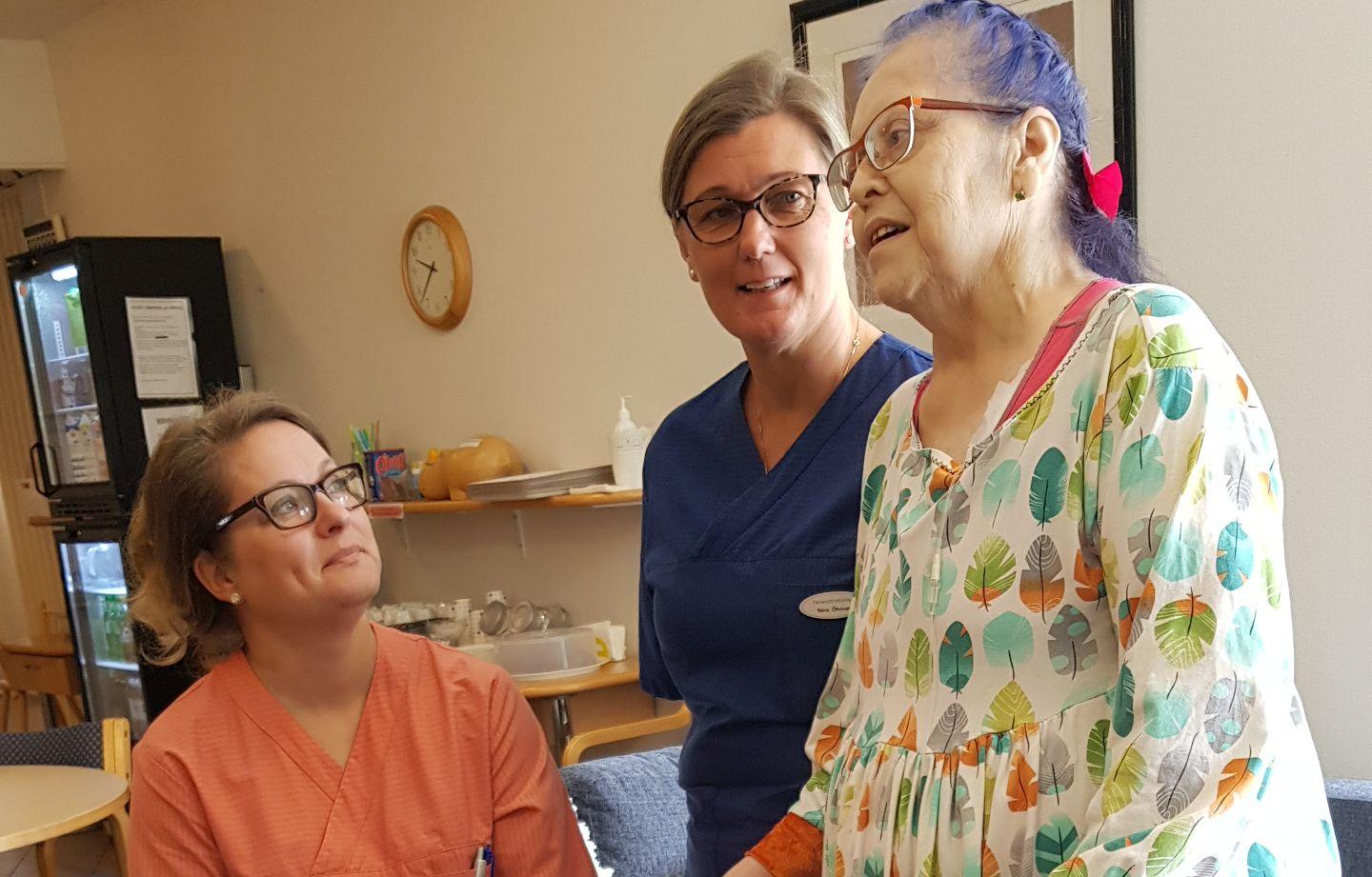 Nina Öhman (tv) och Satu Nurmela, sjukskötare på Karinahemmet i Åbo, tillsammans med patienten Maria Laitakari.
