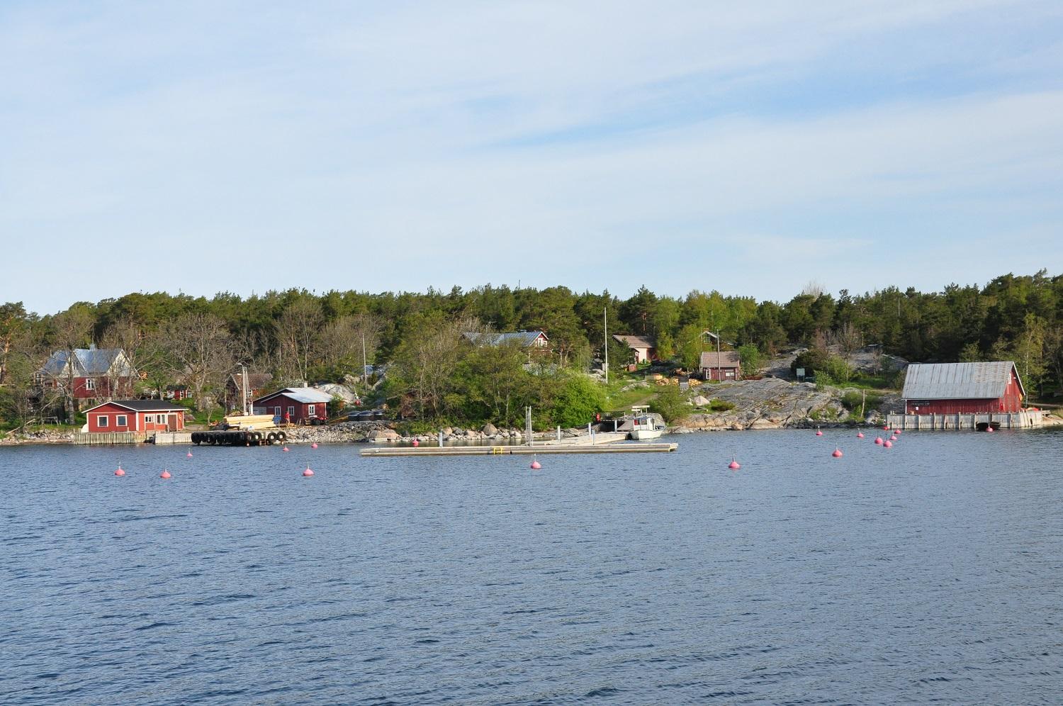 Skärgårdsö med flera gamla röda hus och båthus.