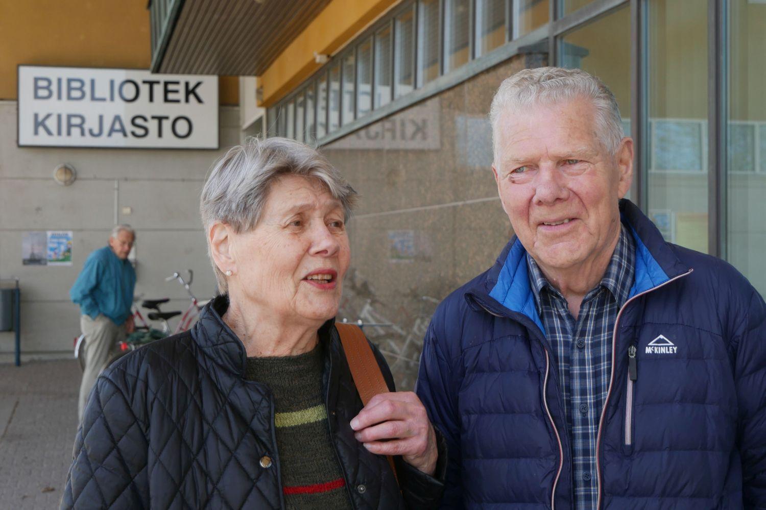 Äldre kvinna och man framför hus