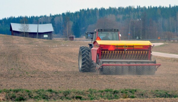 Traktor och såmaskin på åker