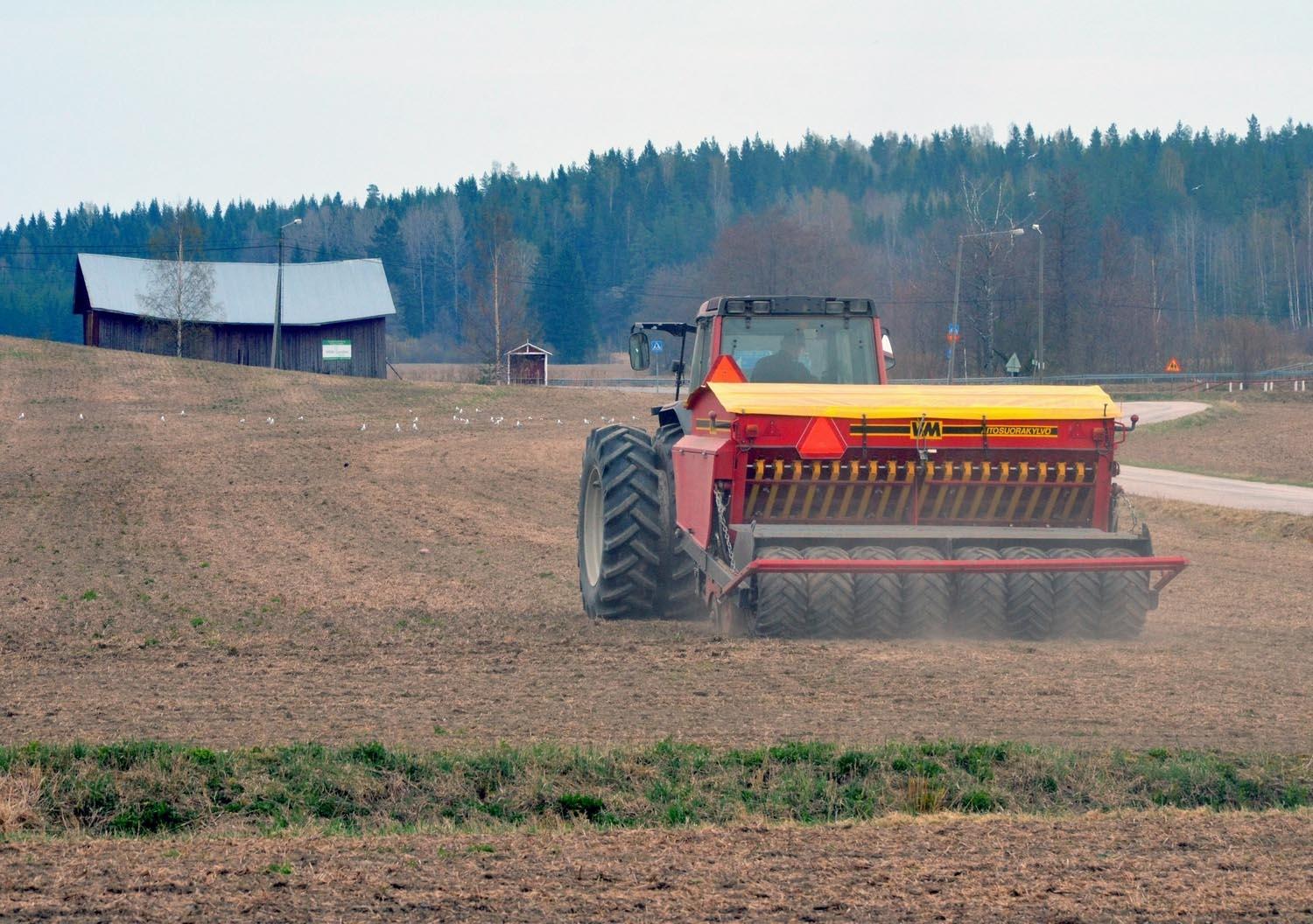 Traktor och såmaskin på åker