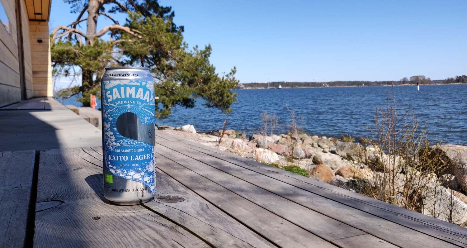 En ölburk på en terrass med vatten i bakgrunden.