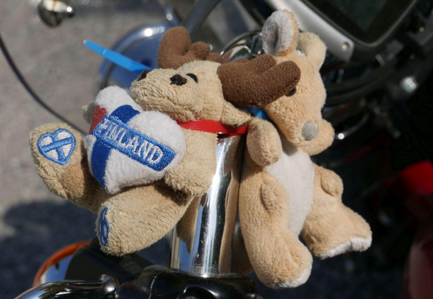 Två små mjukisdjur på ett motorcykelstyre