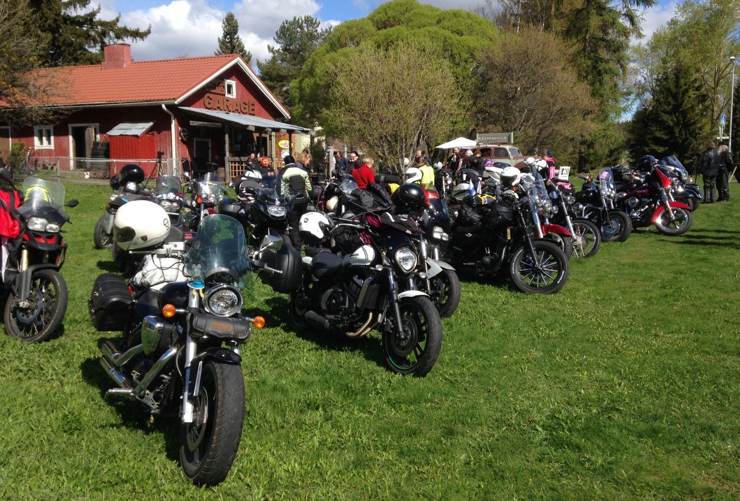 Motorcyklar står på gräsmatta framför gammalt hus