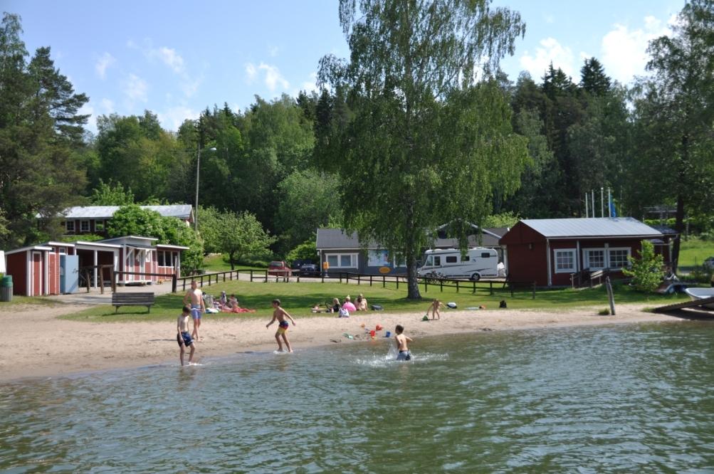 Lekande barn på sandstrand.