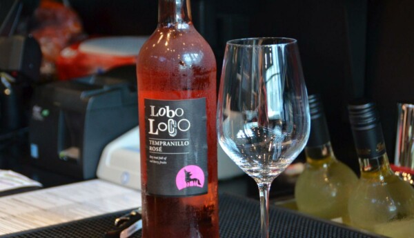 En flaska rosévin och ett vinglas avbildat.