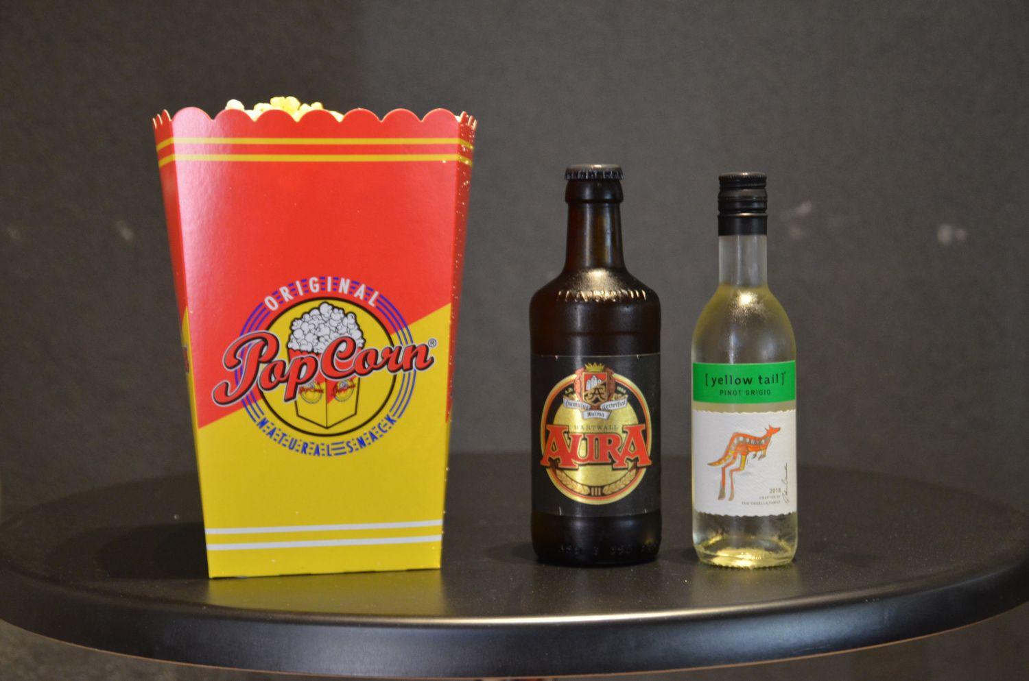 Ett paket popcorn, en öl och en liten flaska vittvin avbildat.
