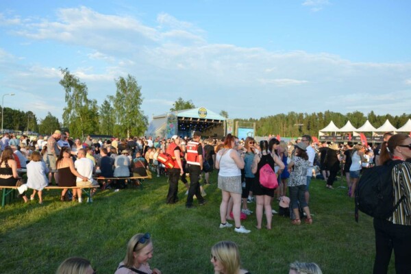 Människor på ett festivalområde i solsken.