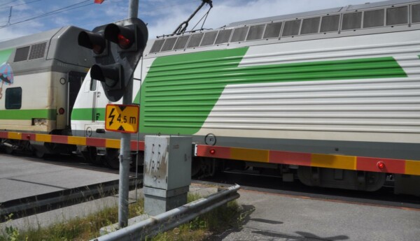 Tåg passerar övergång med bommar