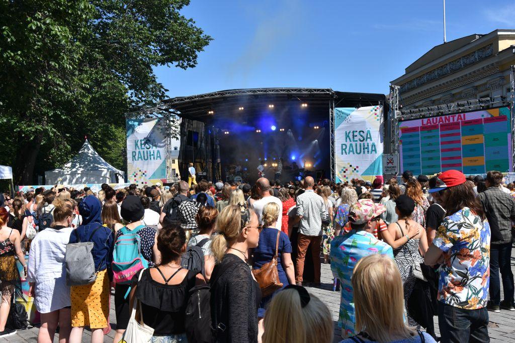 Ett människohav framför en festivalscen, solen lyser.