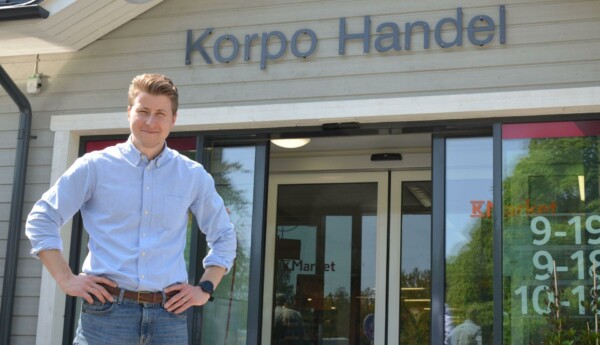 En man står framför ingången till matbutiken Korpo Handel.