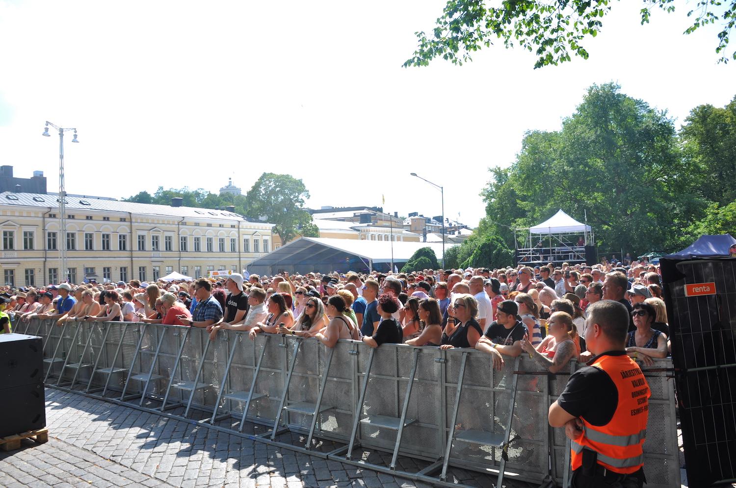 En stor folkmassa på en festival bakom ett staket.