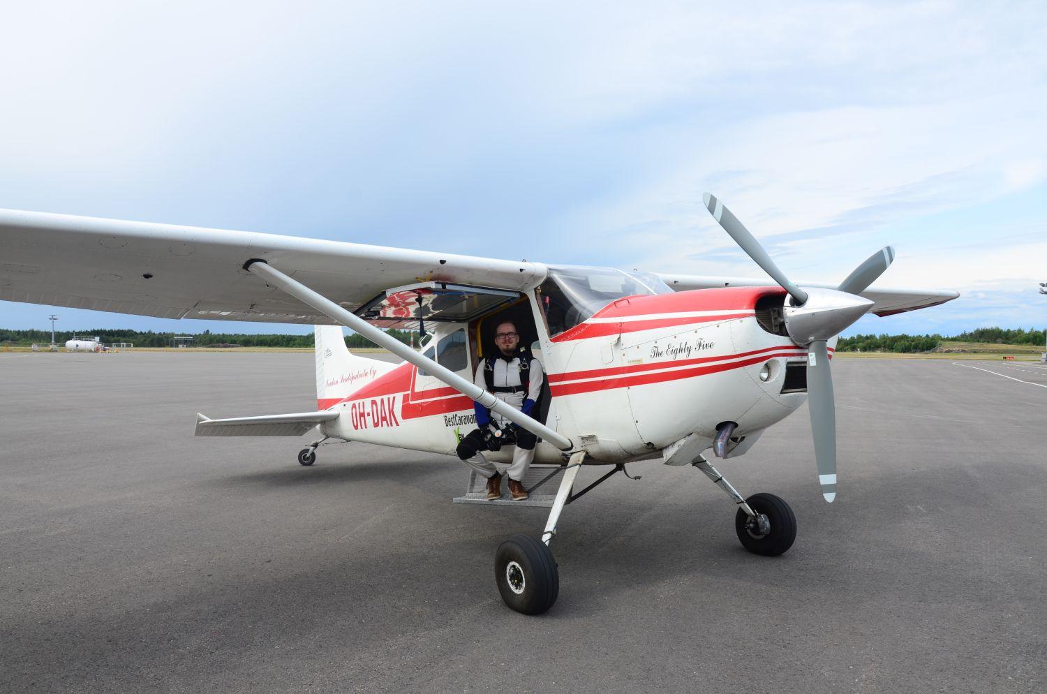 Vilho Kivihalme iklädd fallskärmsutrustning, sitter i Åboföreningens lilla flygplan på Åbo flygfält.