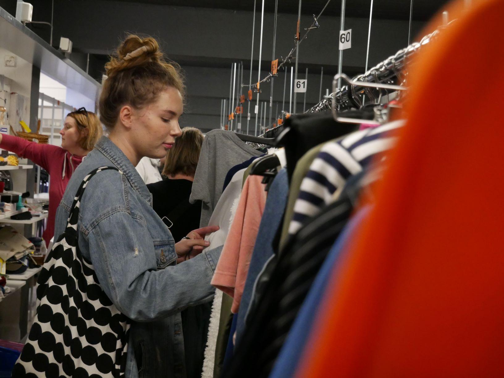 En person kollar in kläder på loppmarknad