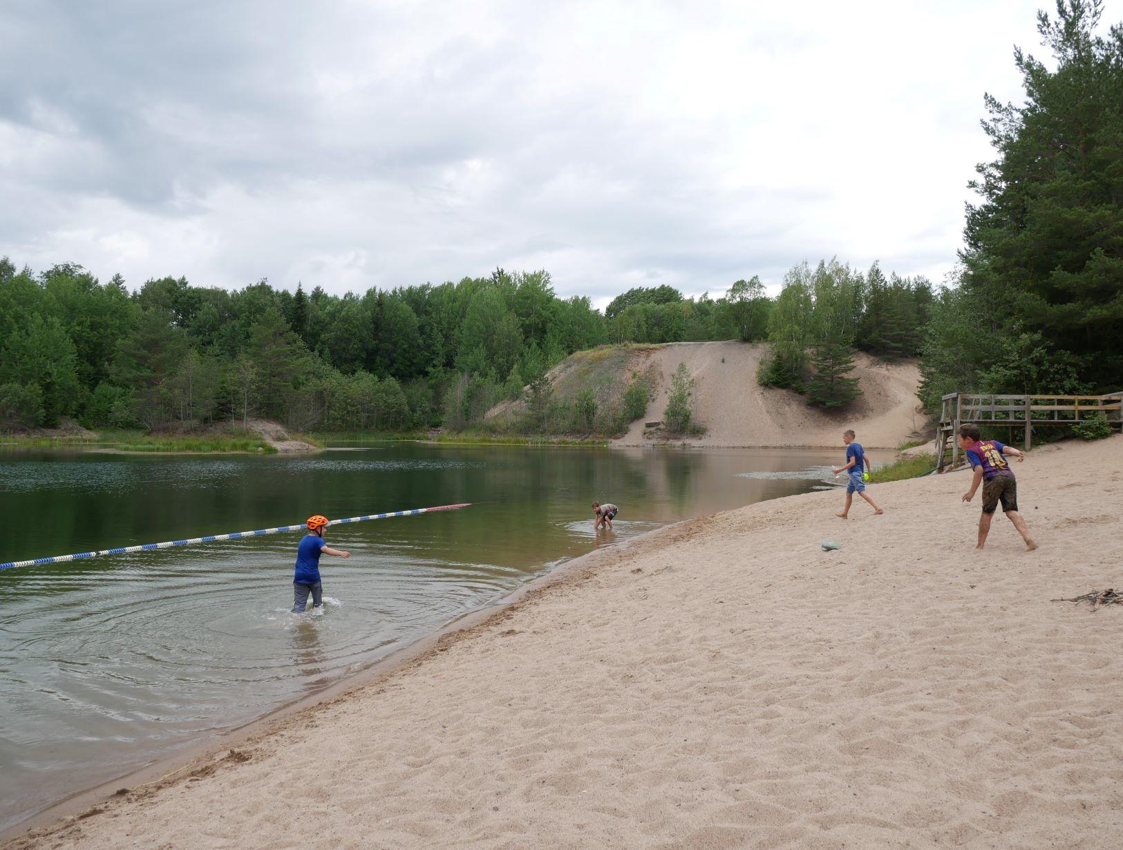 Barn leker vid det gamla sandtaget som är en sjö
