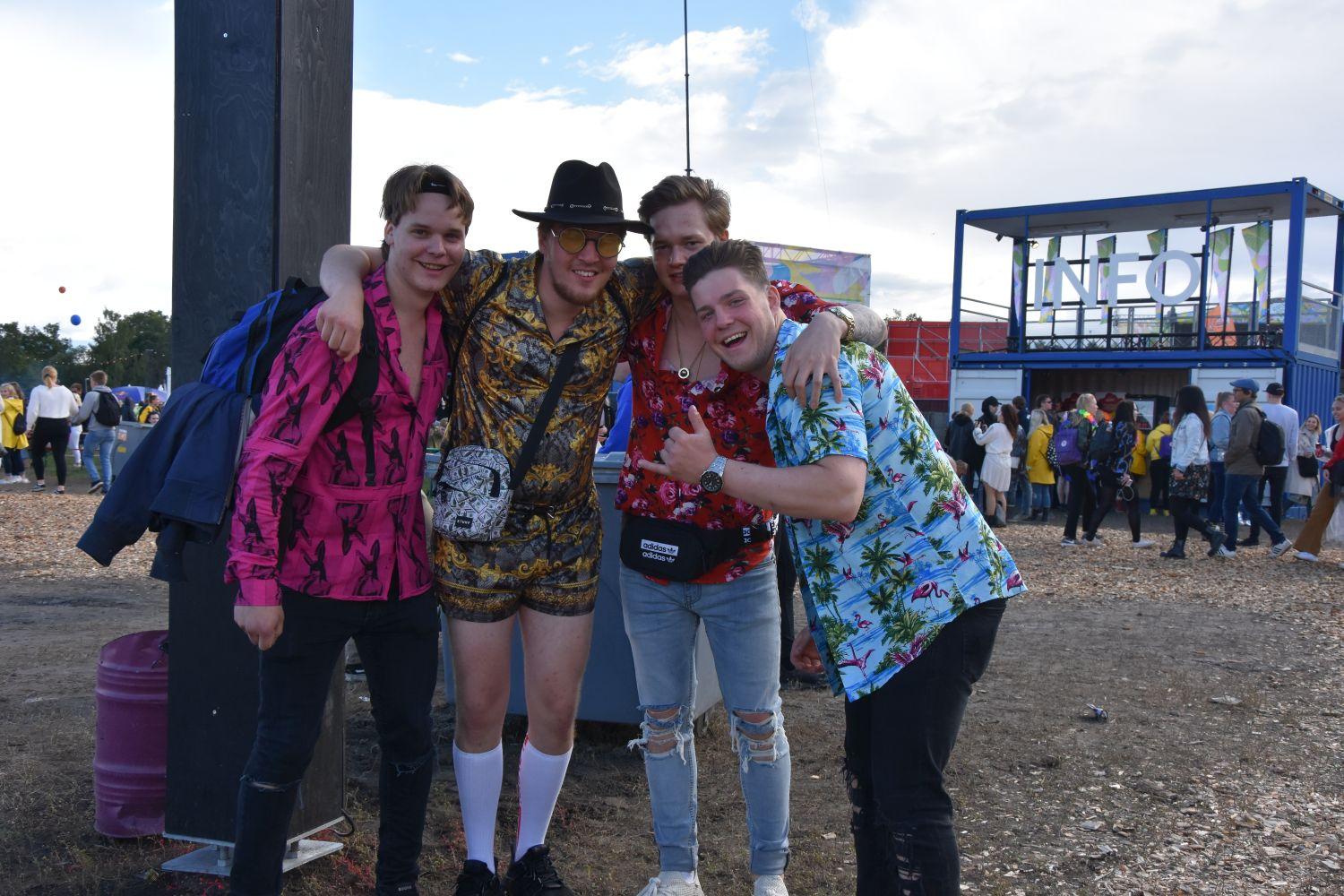 Fyra män i t-skjorta på en festival