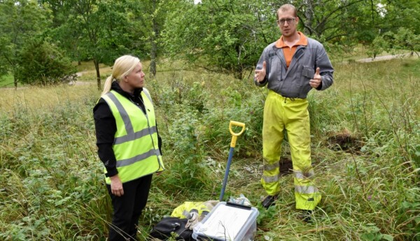 En man och en kvinna står vid ett hål de grävt i marken.