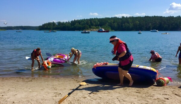 Människor på en strand med flottar.