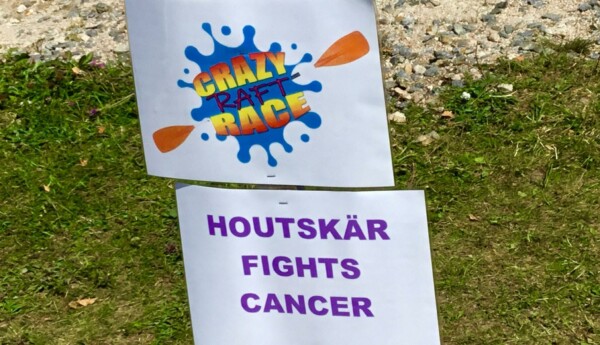 En skylt med texten "Crazy raft race" och "Houtskär fights cancer"