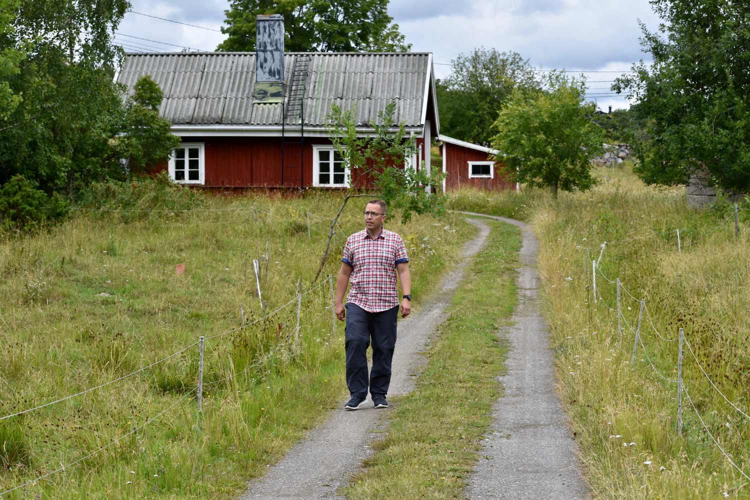 Man går på väg i skärgårdsmiljö.