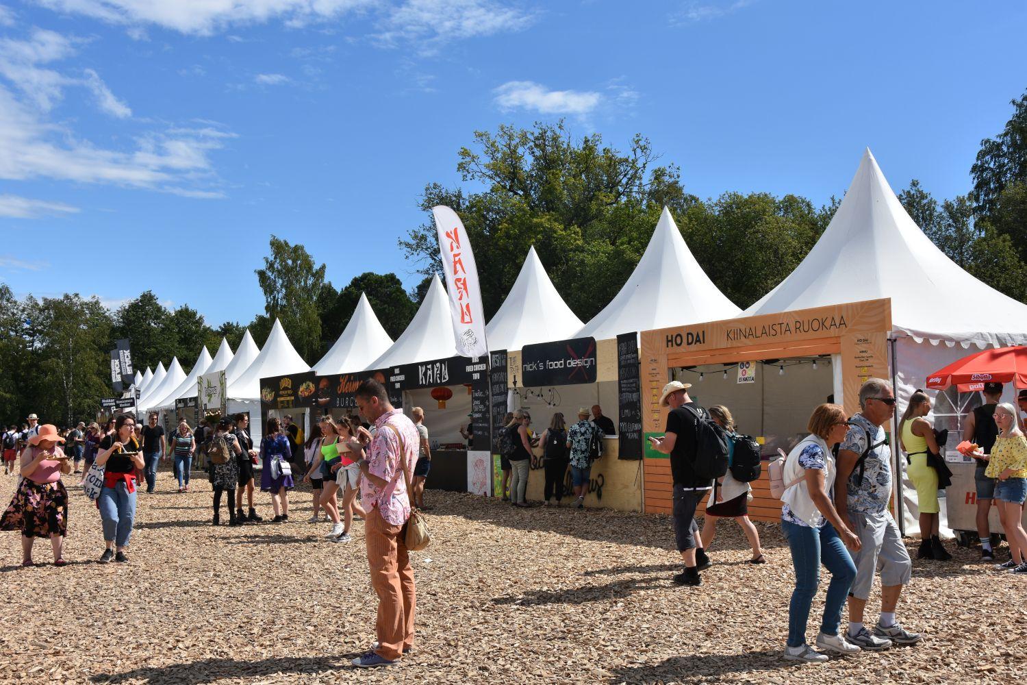 Tält med olika restauranger och festivalbesökare som köar till dem.