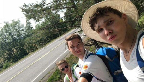 tre unga män vid en landsväg. Bilden är tagen som en selfie.