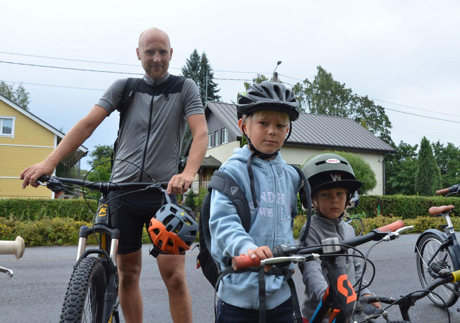Pappa med två söner på cykel