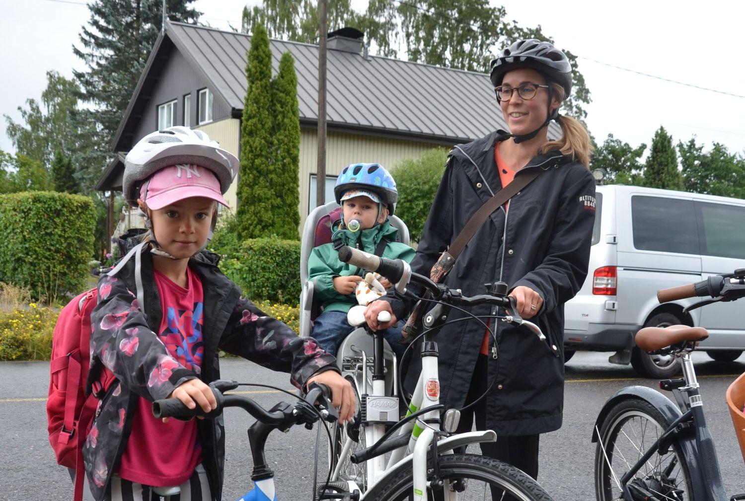 Två flickor och deras mamma på cykel