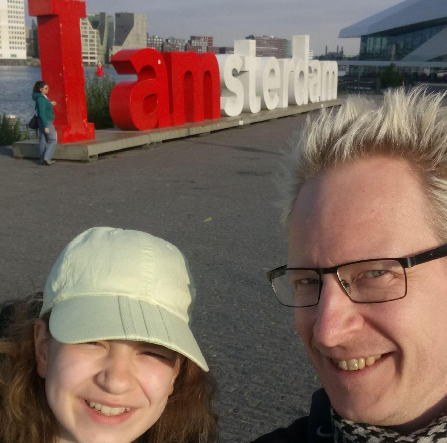 Far och dotter vid en Amsterdam-skylt.