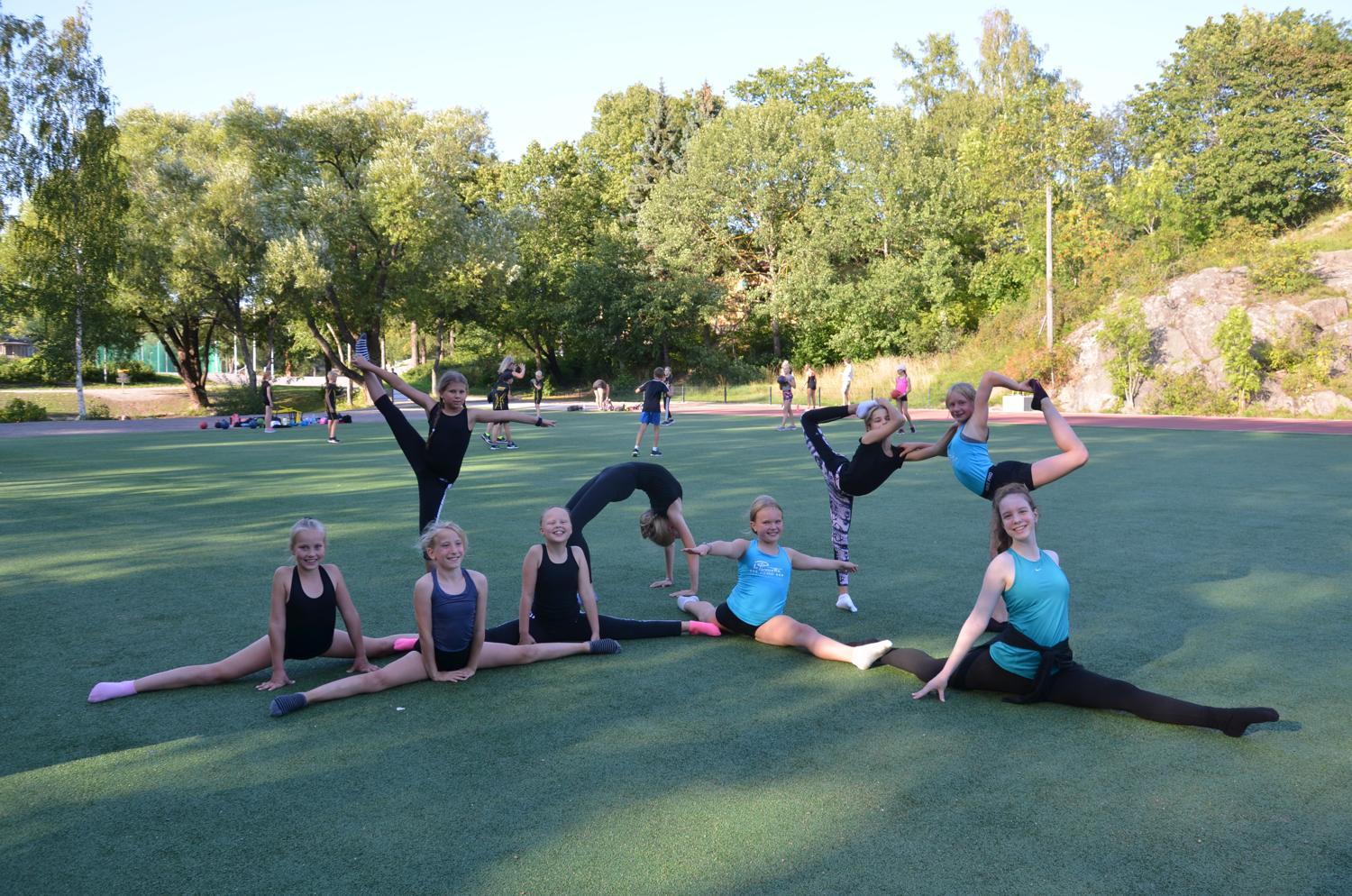 Flera gymnaster som sitter i spagat eller split eller går ner i brygga.