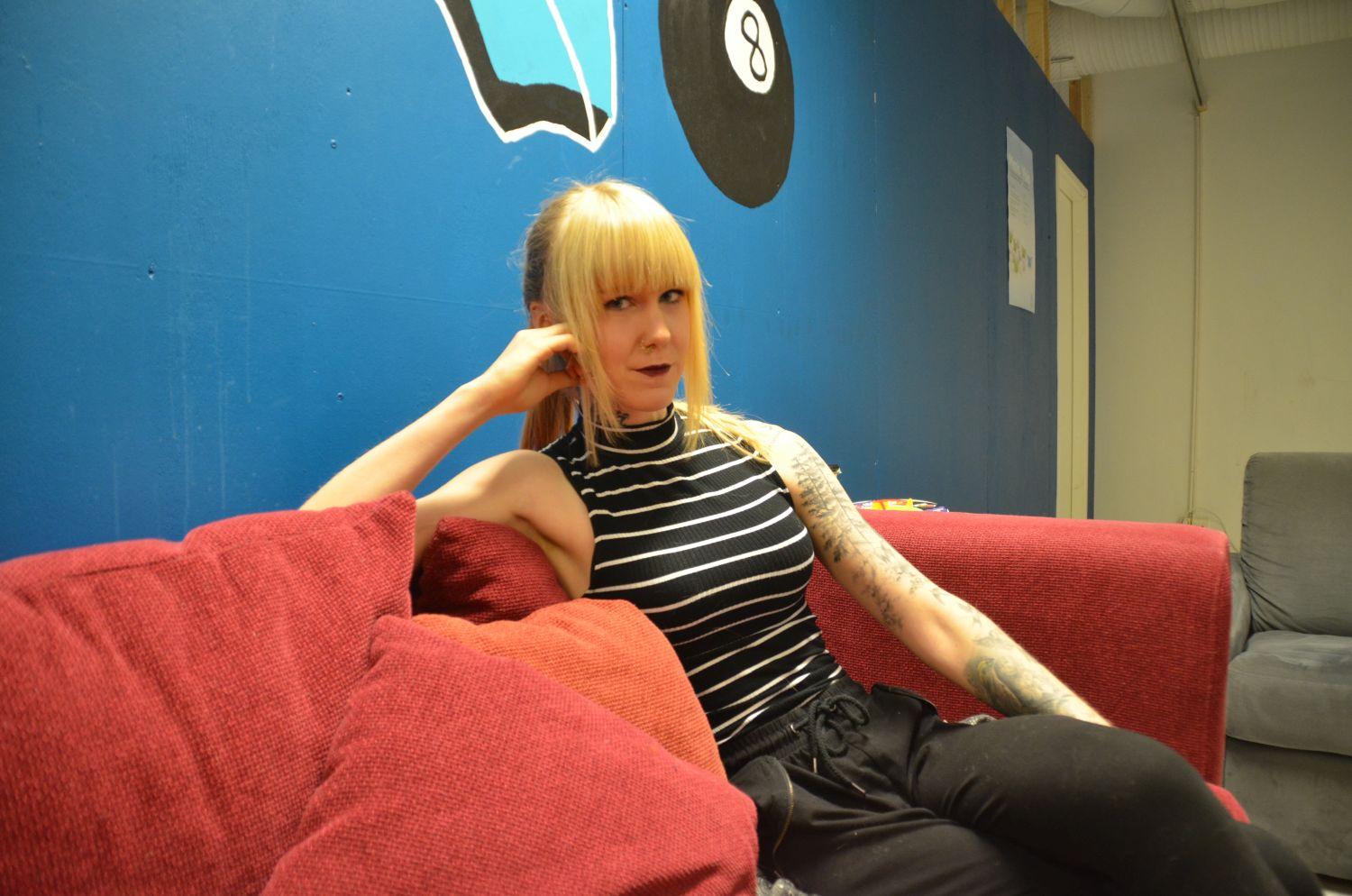 Ung kvinna sitter i en soffa. 