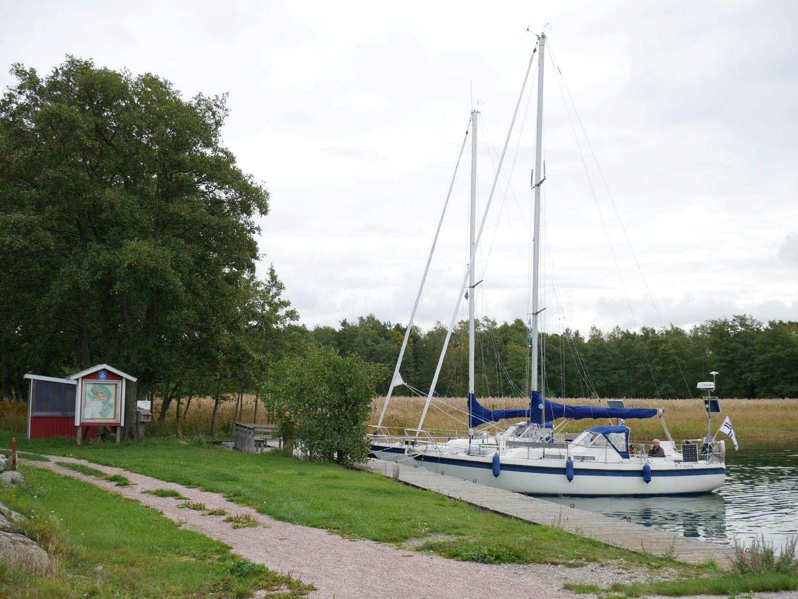 Två segelbåtar är förtöjda vid en brygga