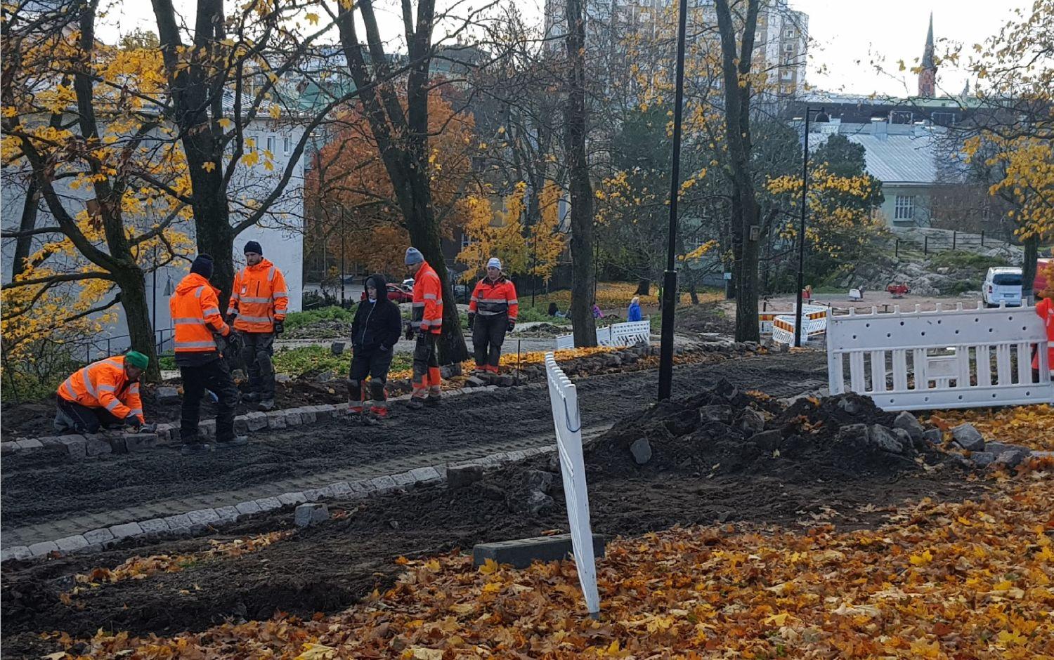 Sex personer lägger sten i park