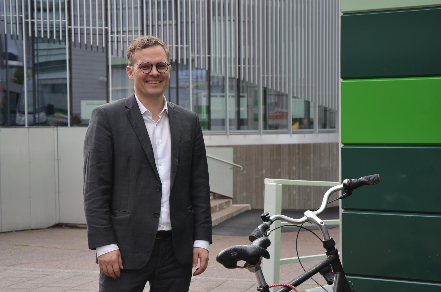 man står vid cykel och grönrandig vägg