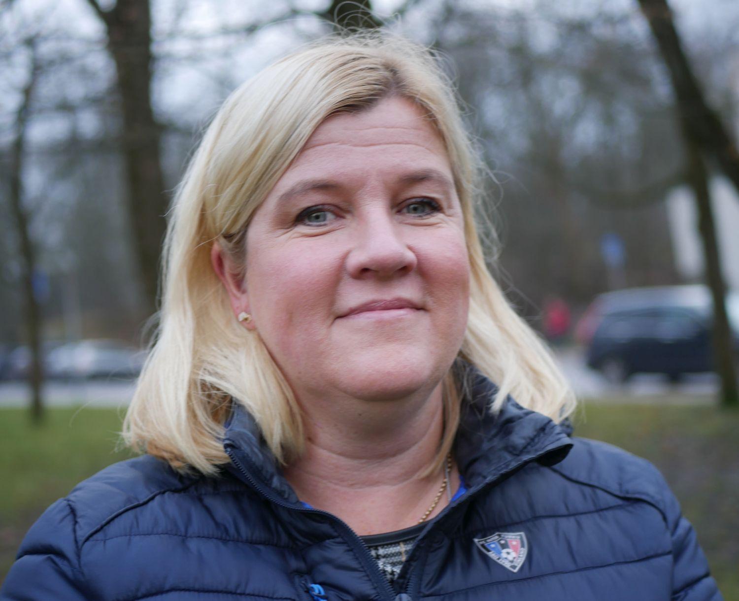 Kvinna som tittar rakt in i kameran och ler