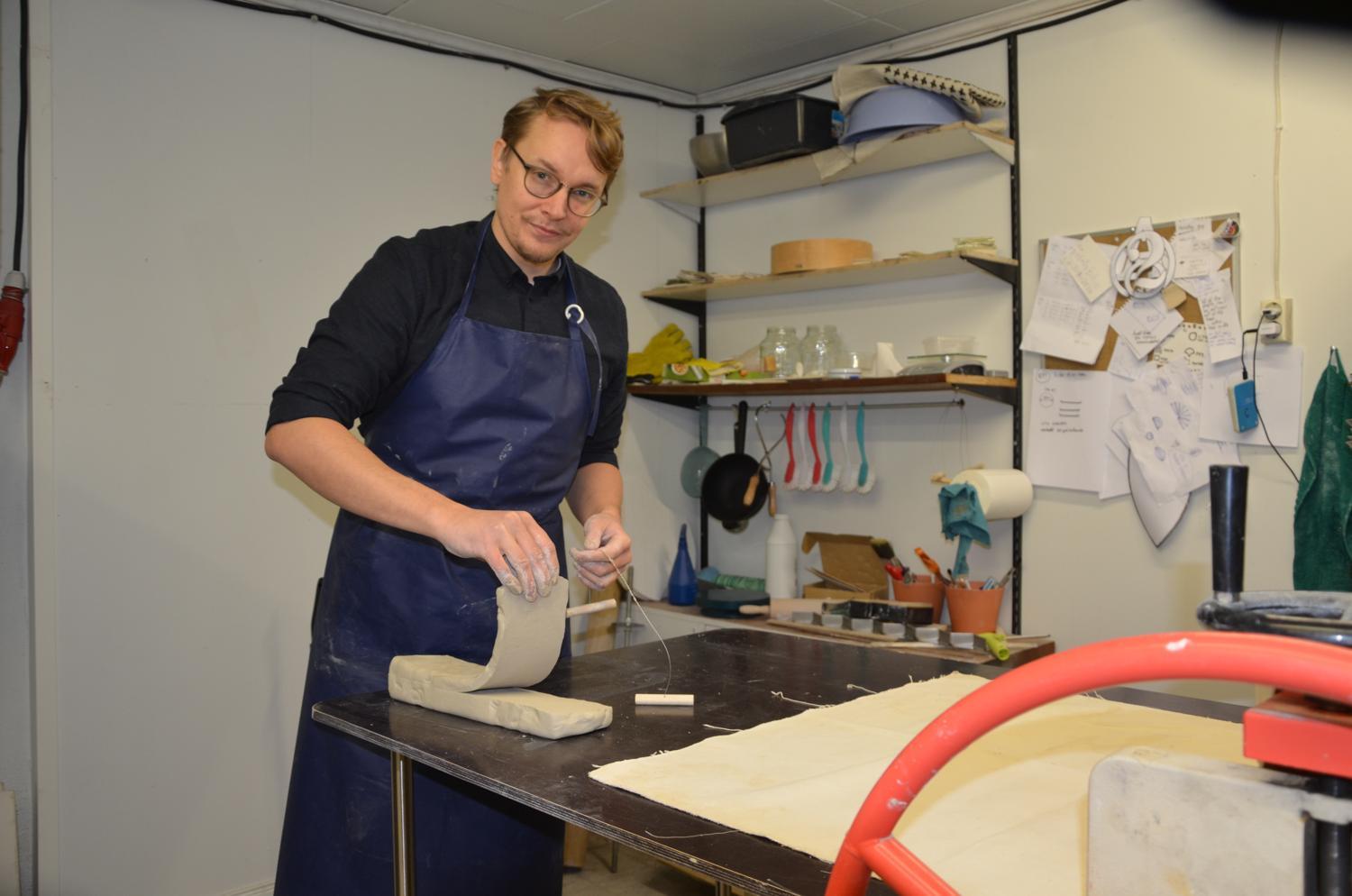 Keramiker skär lerbit med metalltråd