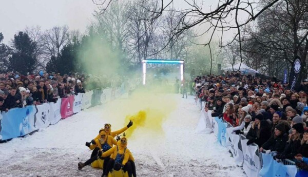 Glada studenter som åker ner för en backe i fantasifulla åkdon.