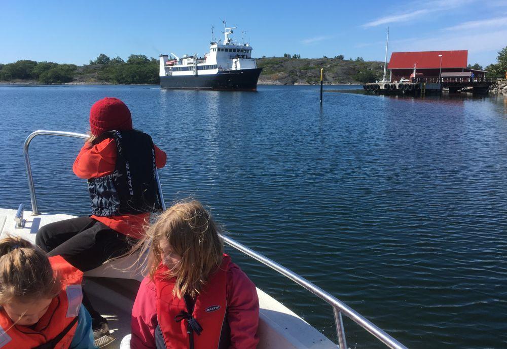 Barn i båt i vacker skärgård