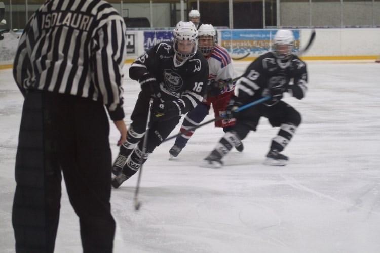 Ishockeyspelare med domare i förgrunden.