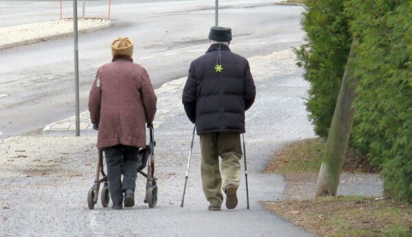 två äldre personer på promenad fotade bakifrån